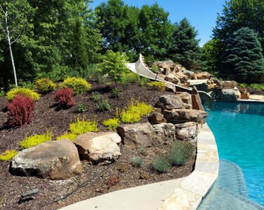 Beautiful poolside landscaping and water slide