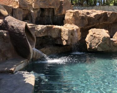 AMAZING concrete rock design with diving platforms and waterslide made to look like a tree.